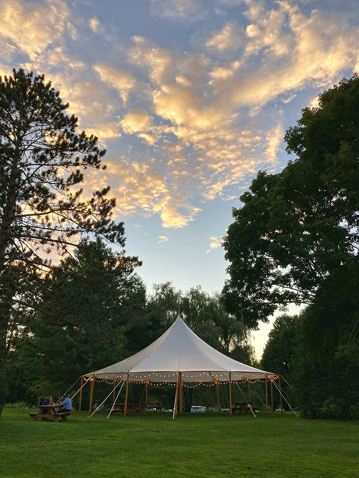 Sailcloth wedding tent on the lawn at Brooklands Farm beneath the evening sky
