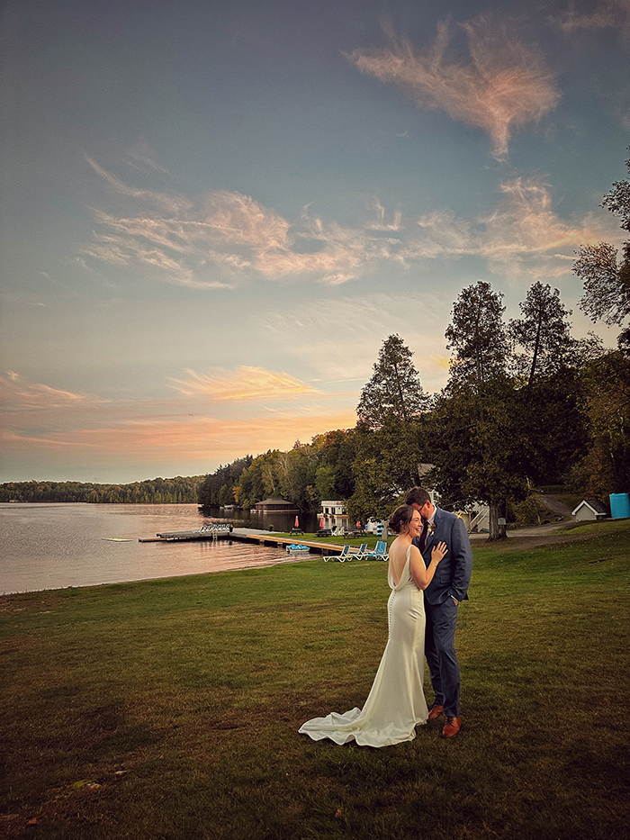 Newlyweds beside Lake of Bays at Port Cunnington Lodge at sunset