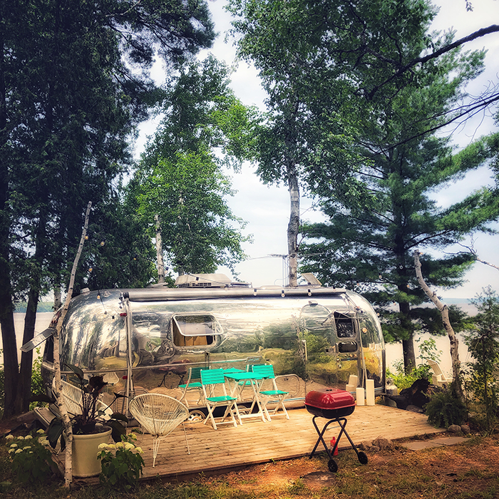 Shining vintage Airstream surrounded by trees at The Northridge Inn and Resort
