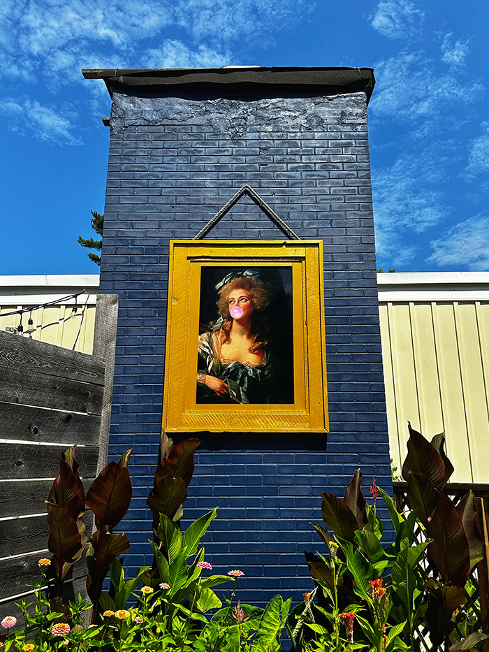Playful bubble-gum portrait against a blue brick wall at The Northridge Inn and Resort